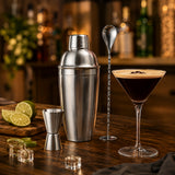 Kit cocktail complet avec shaker et accessoires sur un plan de travail dans une ambiance bar maison chaleureuse